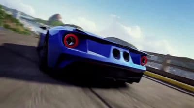 a blue sports car driving down a road