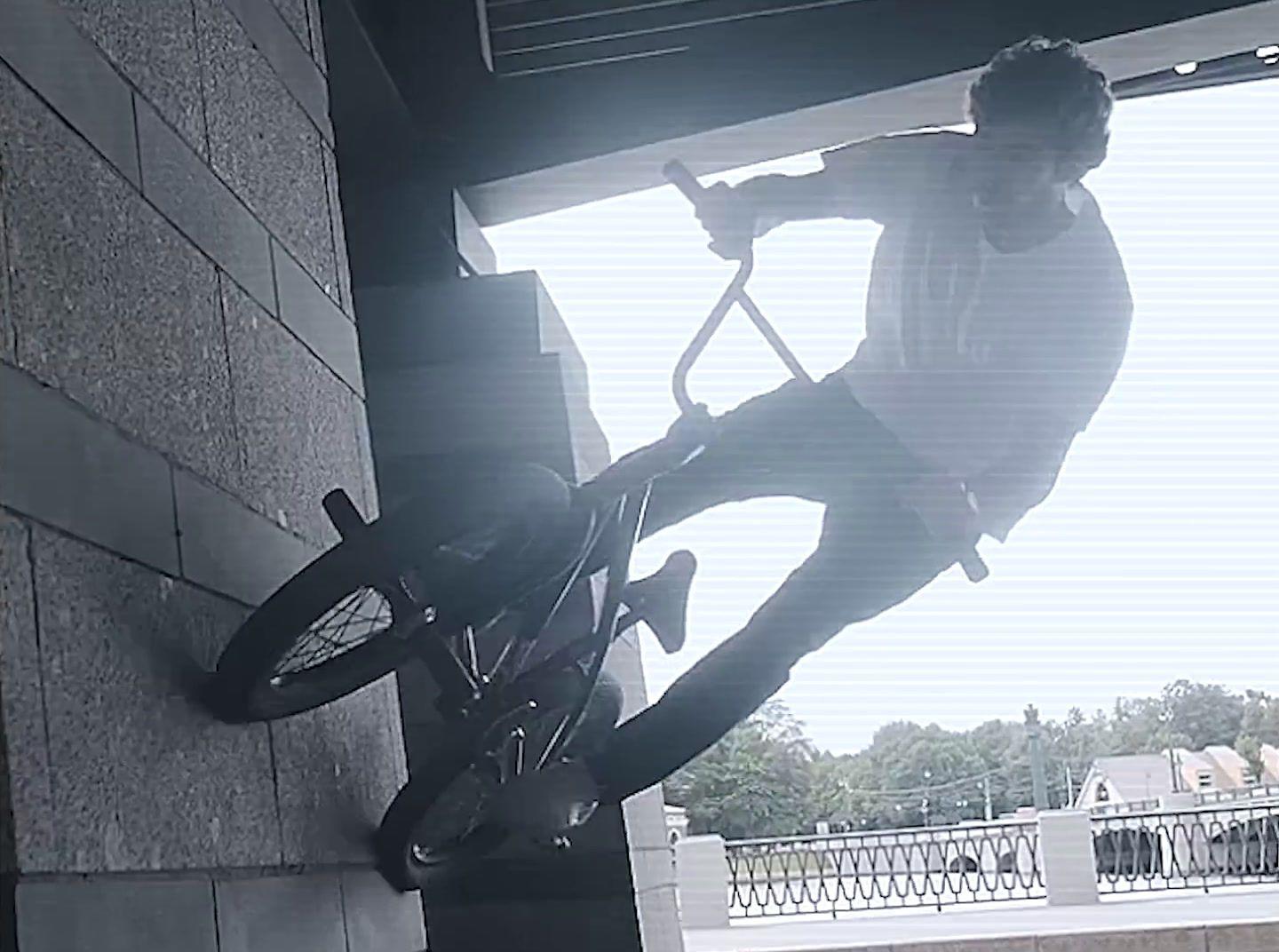 a man riding a bike up the side of a building