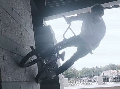 a man riding a bike up the side of a building