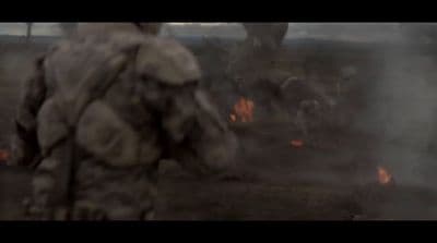 a man standing in front of a fire filled field