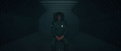 a person sitting in a dark room with a hoodie on