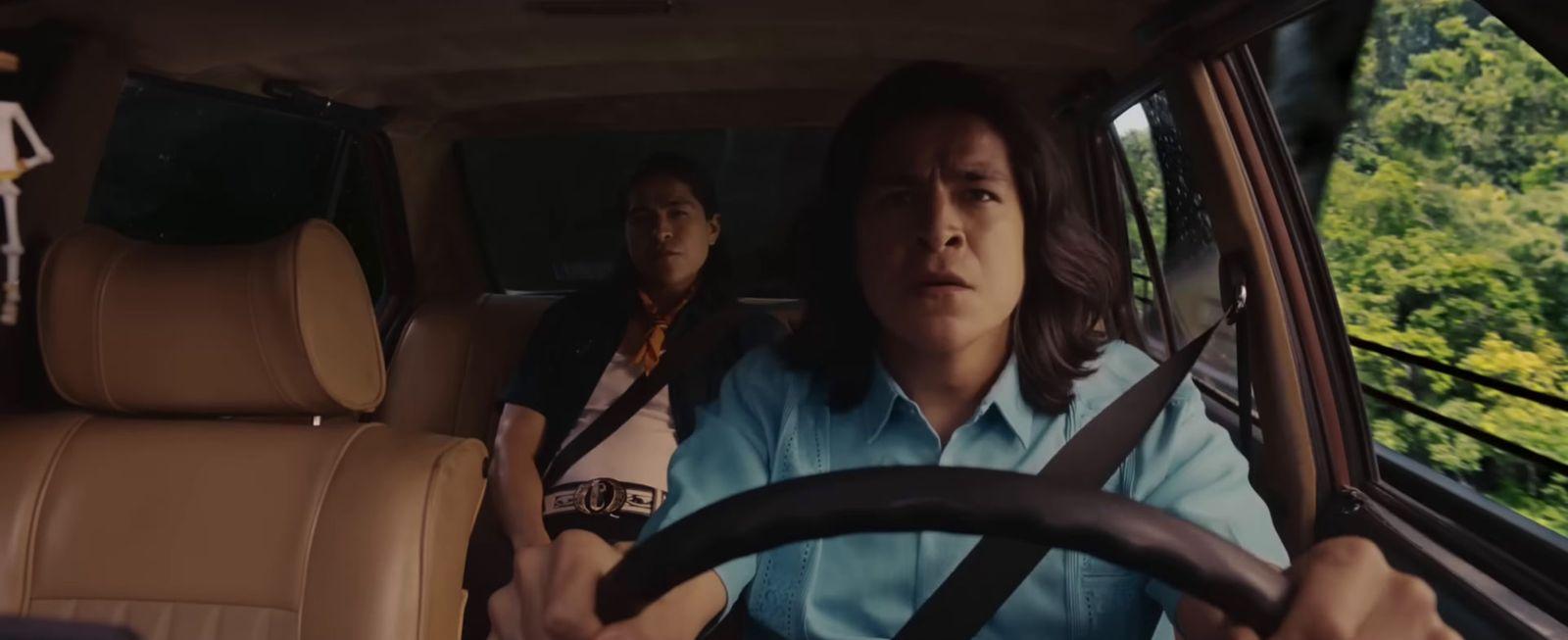 a woman driving a car with another woman behind her