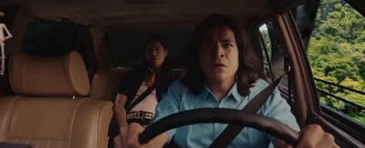a woman driving a car with another woman behind her