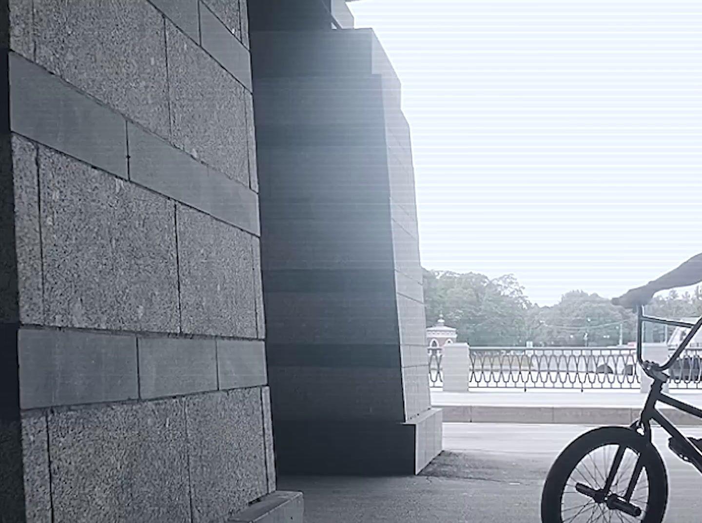 a man riding a bike next to a tall building