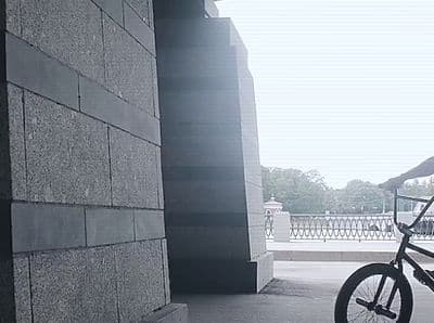 a man riding a bike next to a tall building