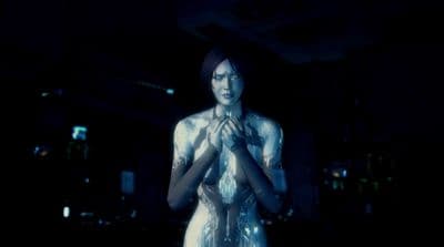a woman standing in a dark room holding her hands together