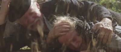 a man laying on the ground covered in mud