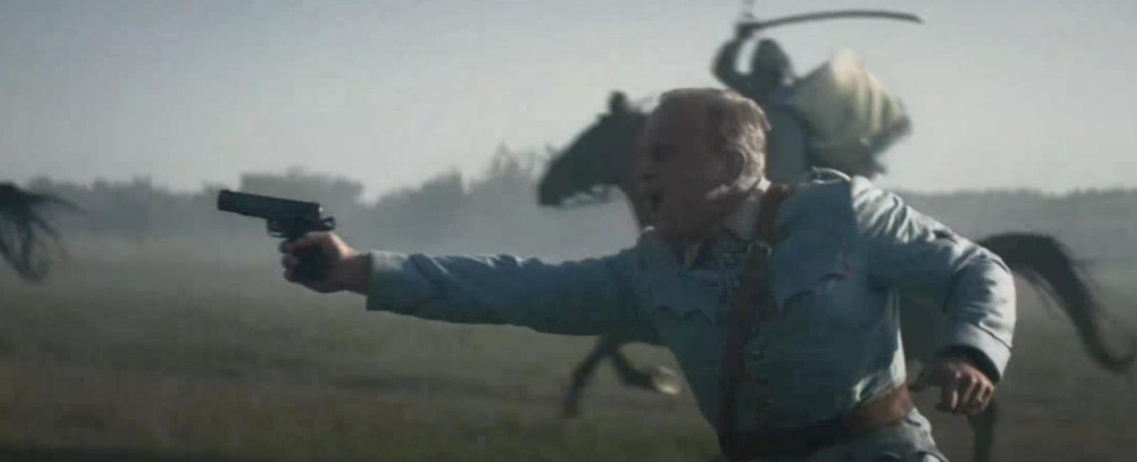 a man holding a gun in a field