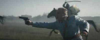 a man holding a gun in a field