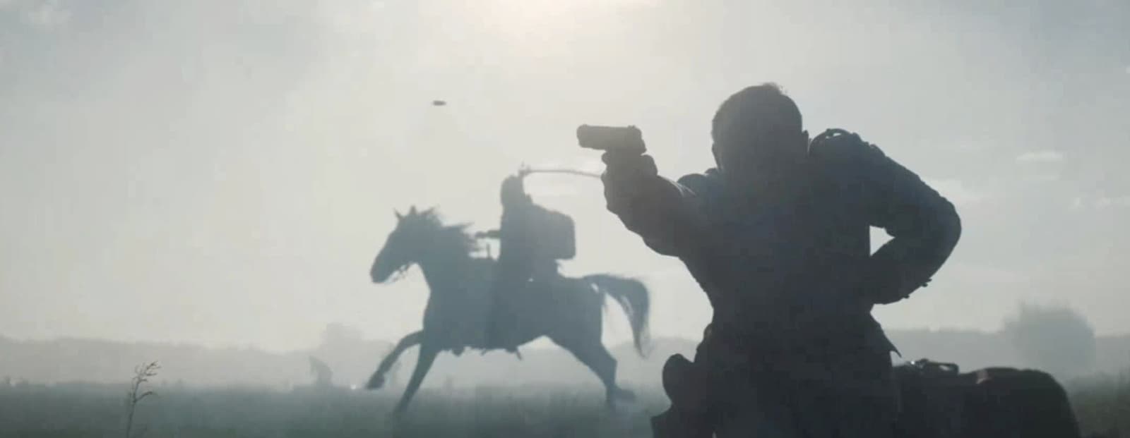 a silhouette of a man on a horse with a gun