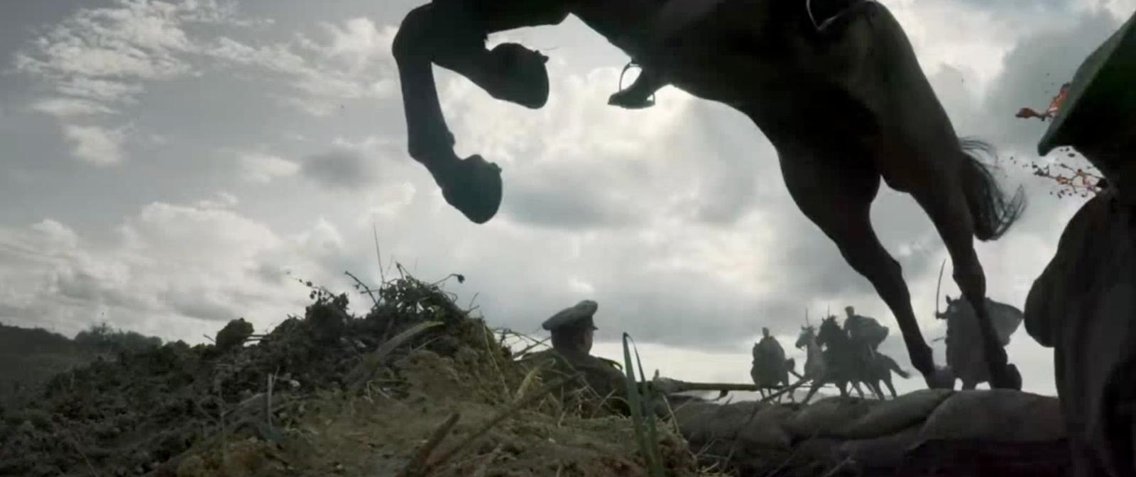 a man riding a horse over a pile of hay