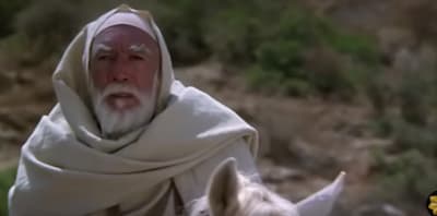 a man in a white robe riding a white horse