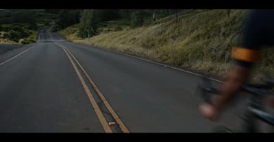 a man riding a bike down a curvy road