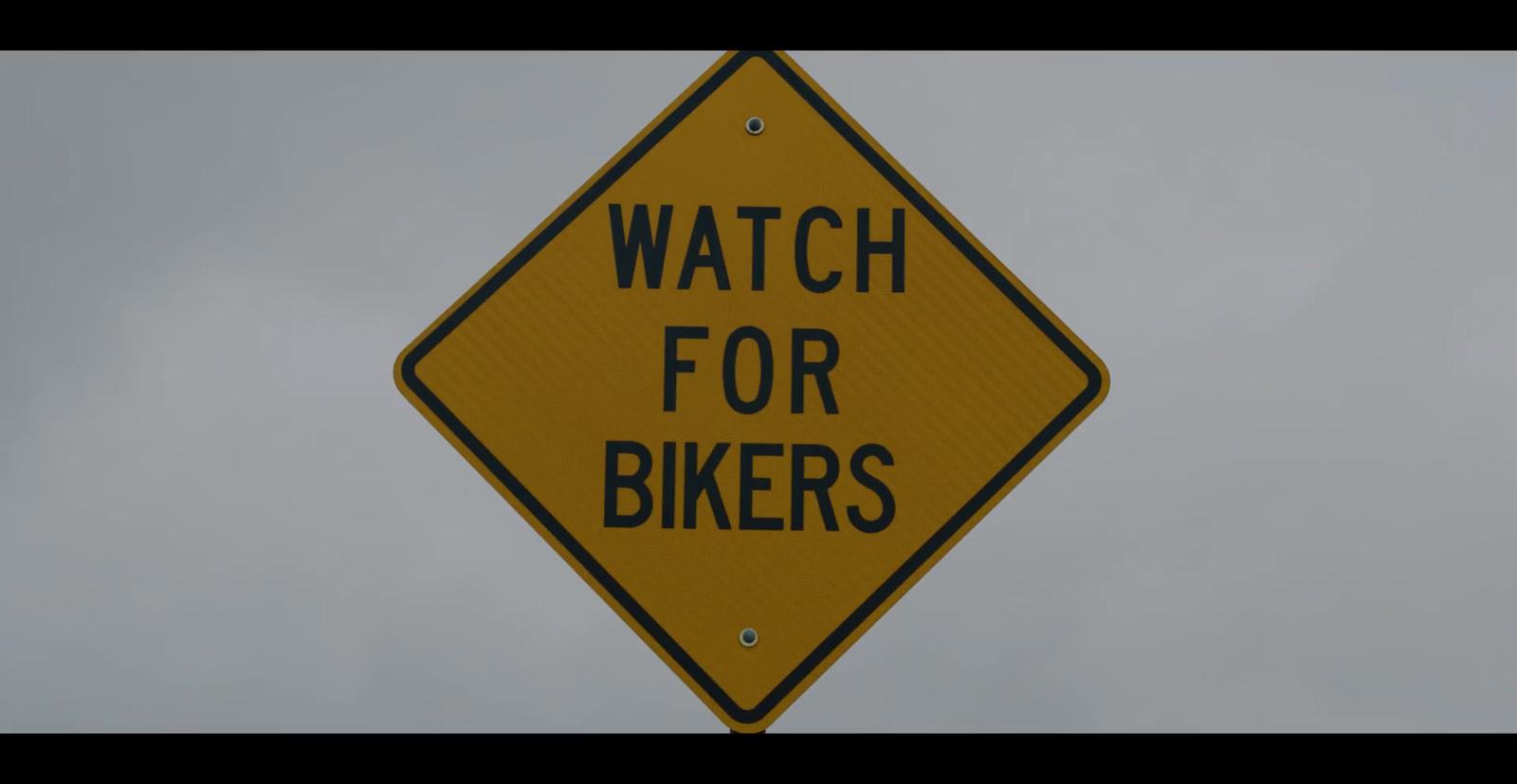 a yellow sign that says watch for bikers