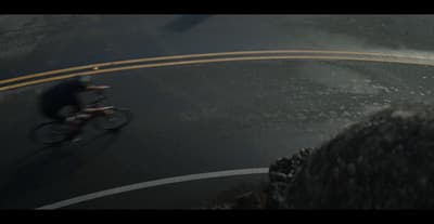 a man riding a bike down a curvy road