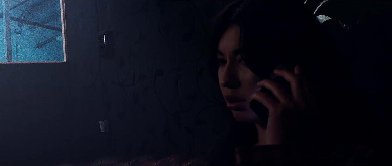 a woman talking on a cell phone in a dark room