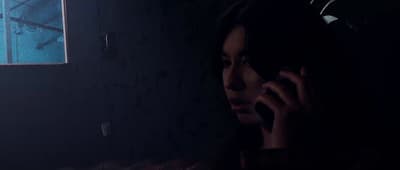 a woman talking on a cell phone in a dark room