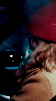 a woman wearing a red hat and a brown coat
