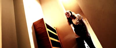 a woman standing in a hallway next to a wall
