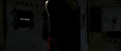 a man standing in a dark room with his back to the camera