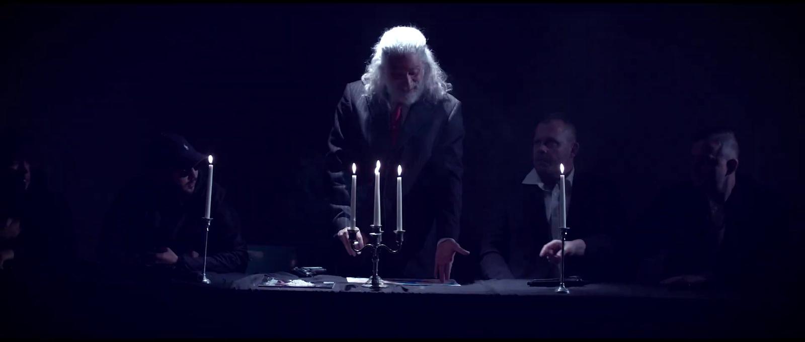 a group of people standing around a table with candles