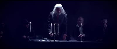 a group of people standing around a table with candles
