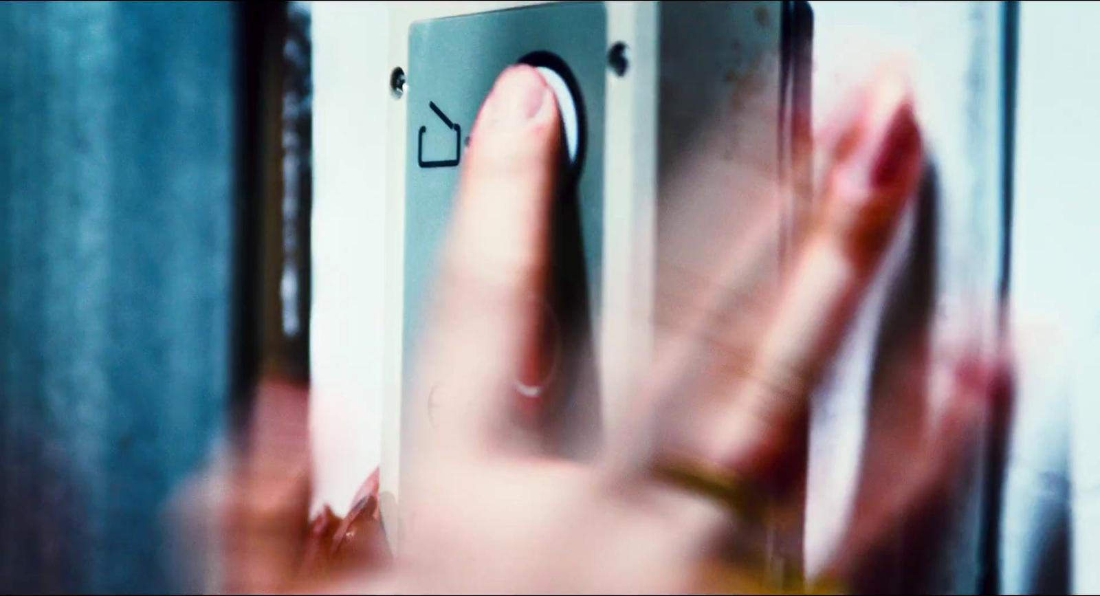 a hand is pressing a button on a door