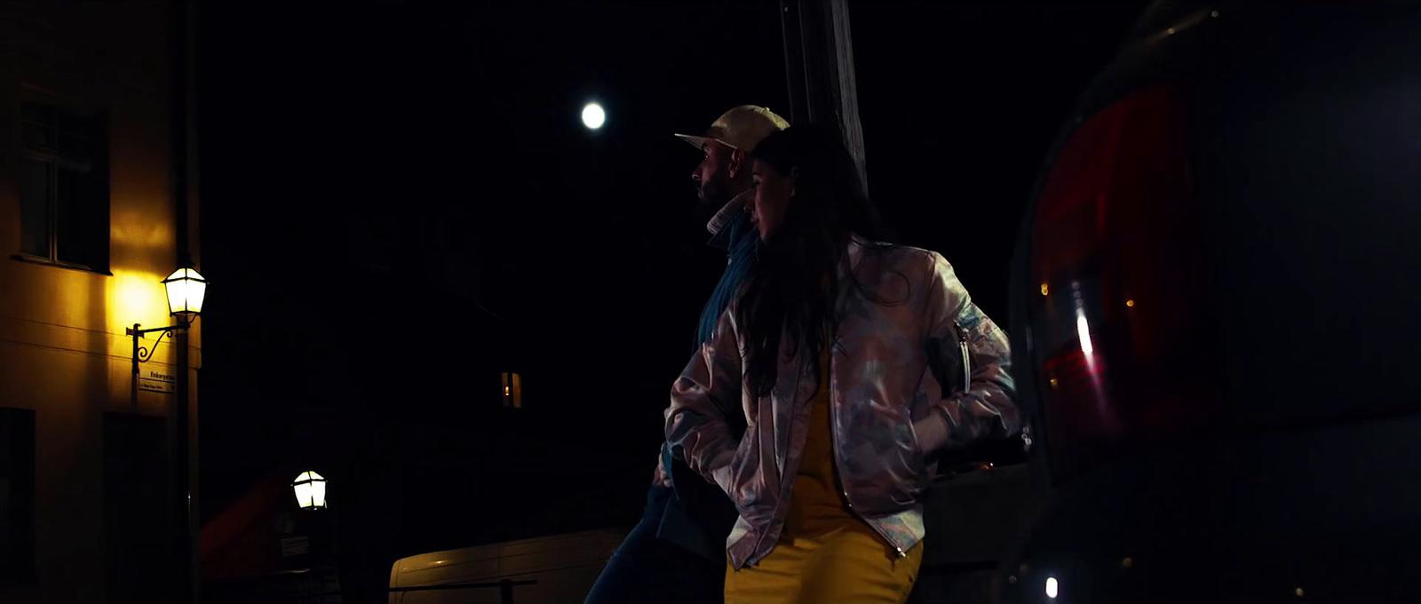 a woman walking down a street at night
