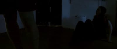 a person sitting on the floor in a dark room