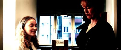 two women standing next to each other in a room
