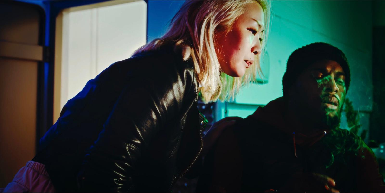 a woman standing next to a man in a dark room