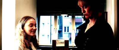 two women standing next to each other in a room