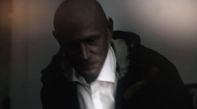 a bald man in a white shirt and black jacket