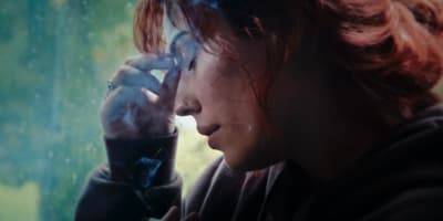 a woman smoking a cigarette in the rain
