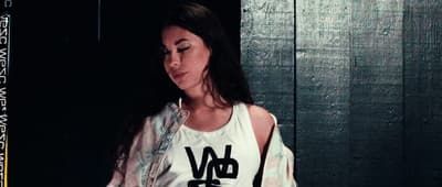 a woman in a tank top holding a cell phone