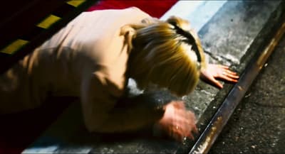 a person bending over on the ground with a knife