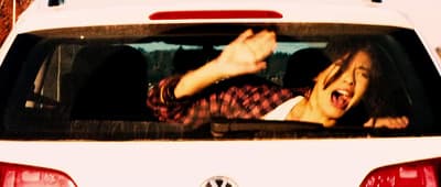 a woman is screaming in the back of a car