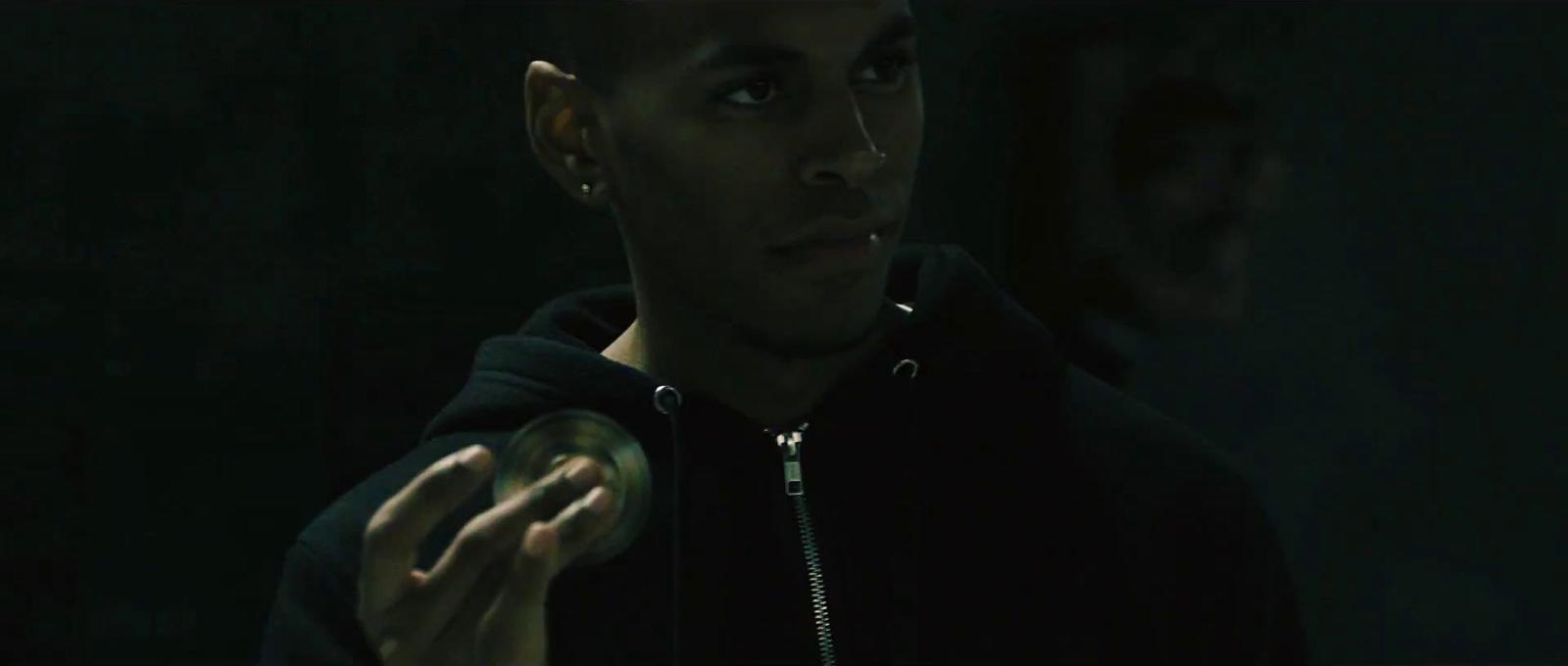 a man in a black hoodie holding a green object