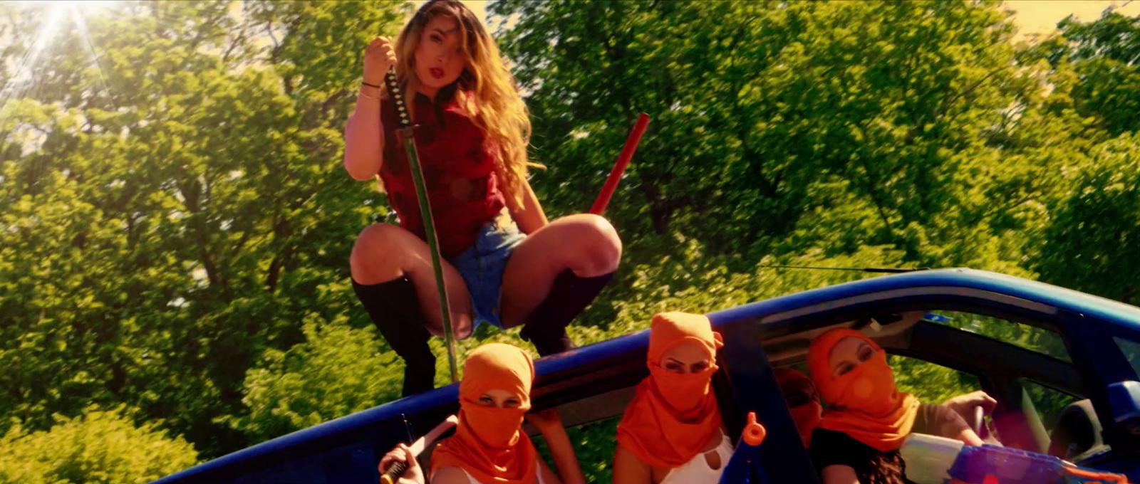 a woman in a red shirt is sitting on a blue car