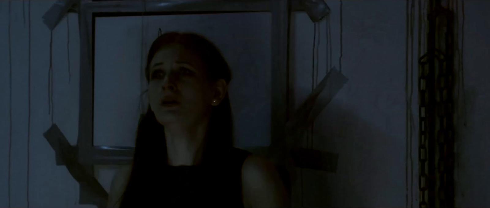 a woman standing in front of a mirror in a dark room