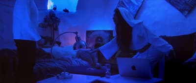 a person sitting in a room with a laptop