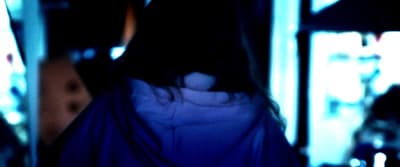 a blurry image of a woman's back in a dark room
