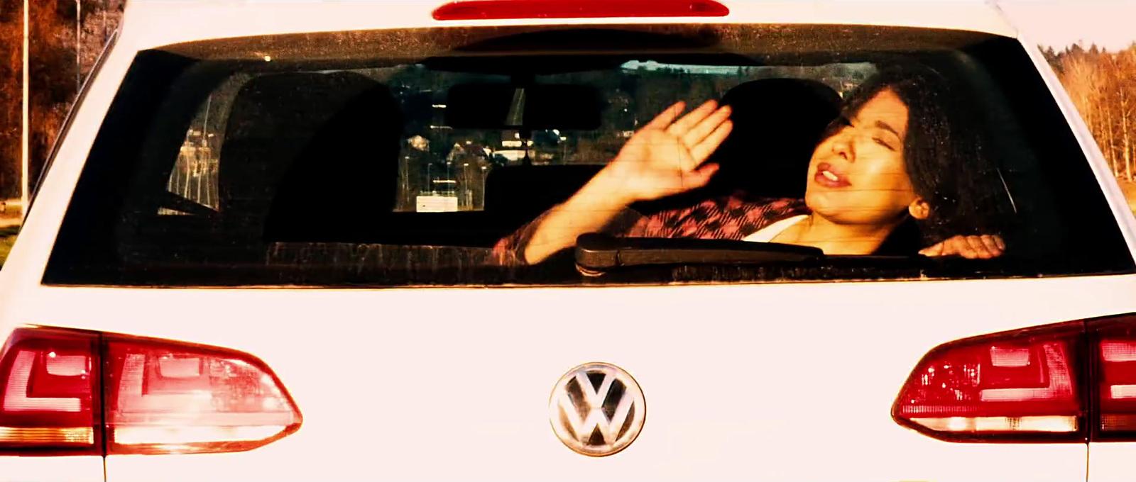 a woman sitting in the back of a white car