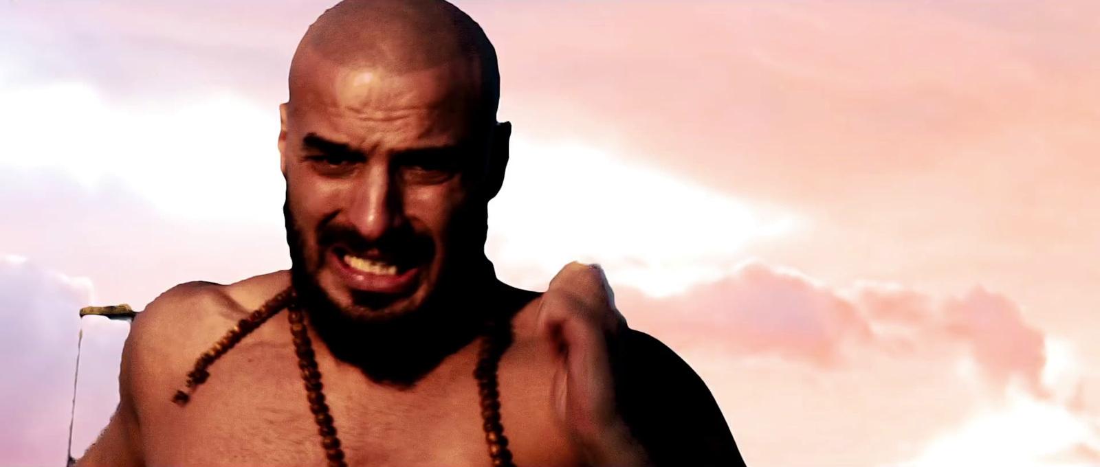 a man with no shirt holding a cell phone