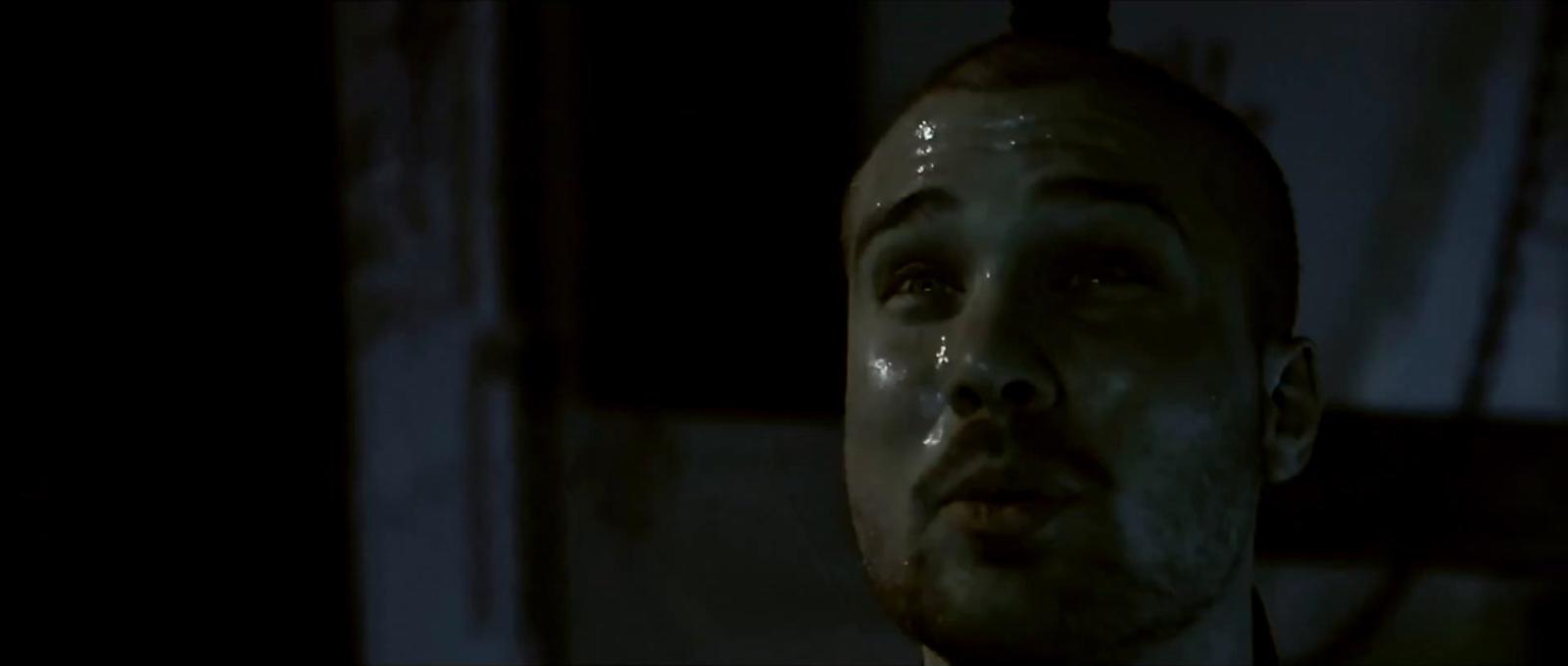 a man in a dark room looking up at something