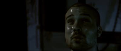 a man in a dark room looking up at something