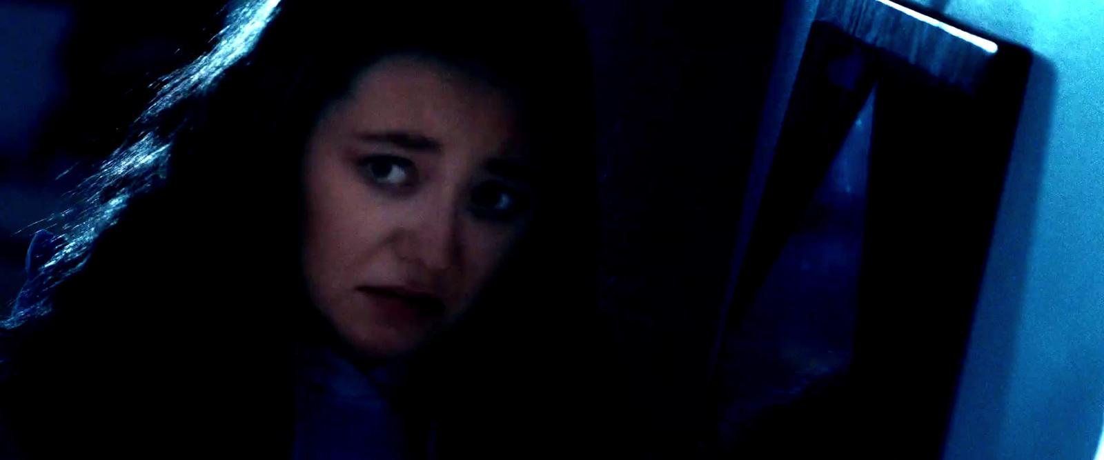 a woman looking at the camera in a dark room