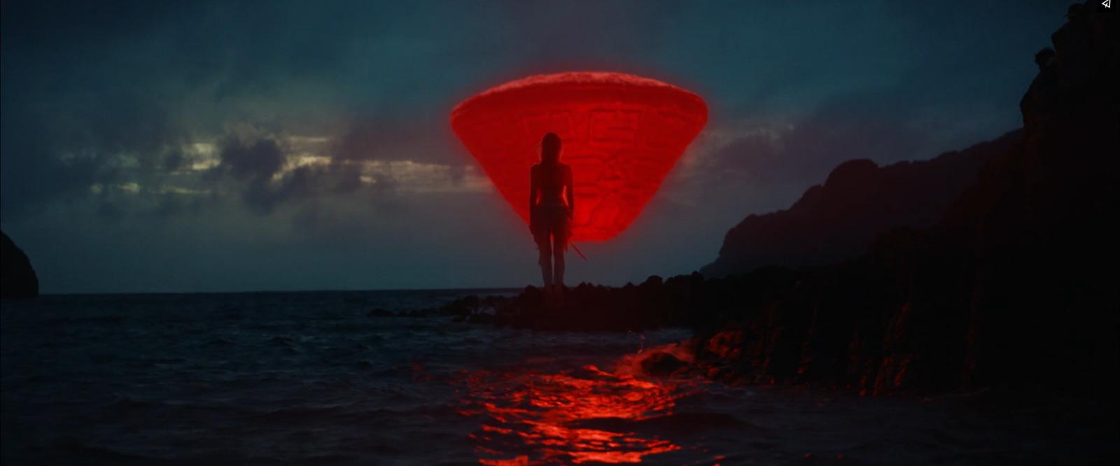 a person standing on a rock in the ocean at night