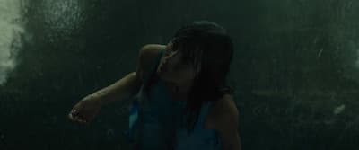 a woman standing in the rain with her hand on her face
