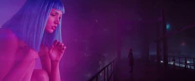 a woman with blue hair standing in a dark room